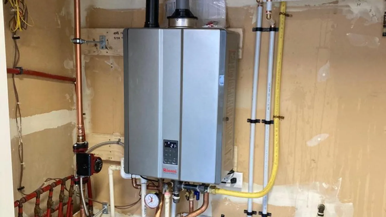 A wall-mounted Rinnai tankless water heater, its copper and PEX lines run down to a manifold below it.